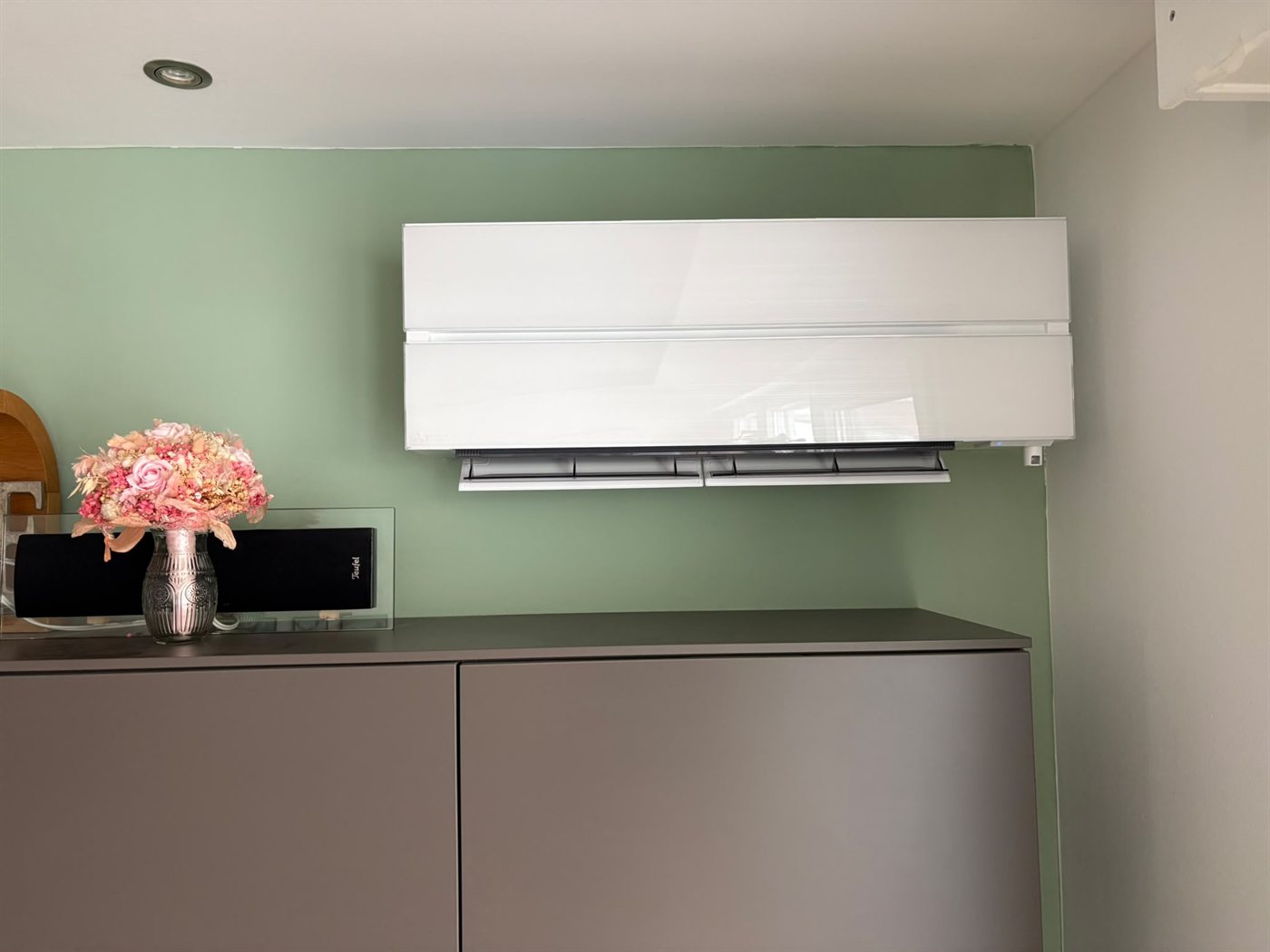 Wandgerät einer Klimaanlage über einem Sideboard in einem Wohnzimmer